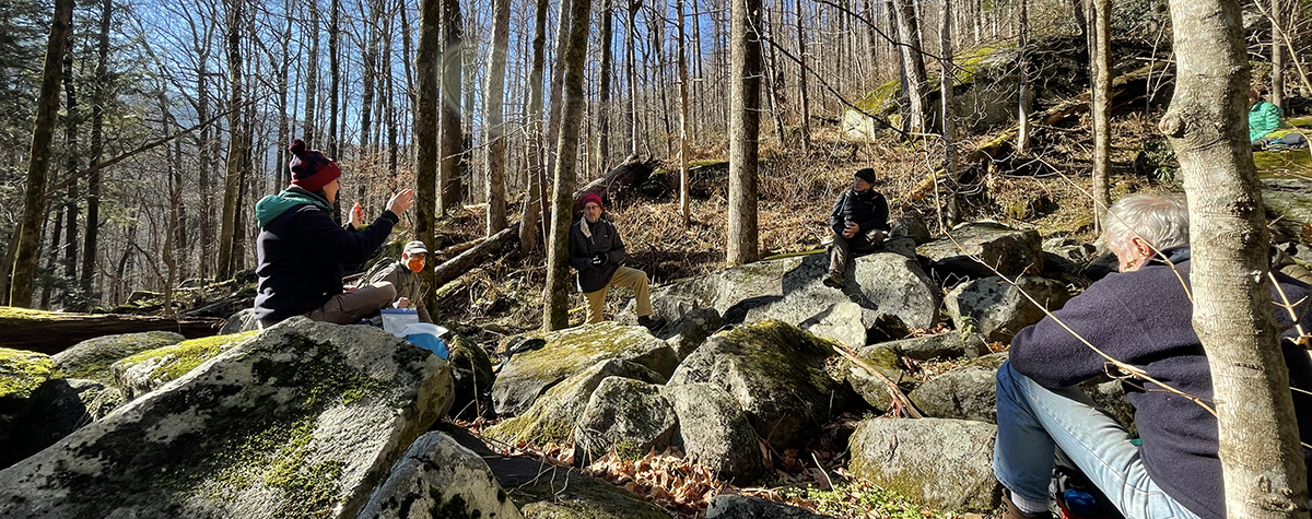 Group of people sitting on rocks in the Great Smoky Mountains National Park during a Tremont geology workshop.