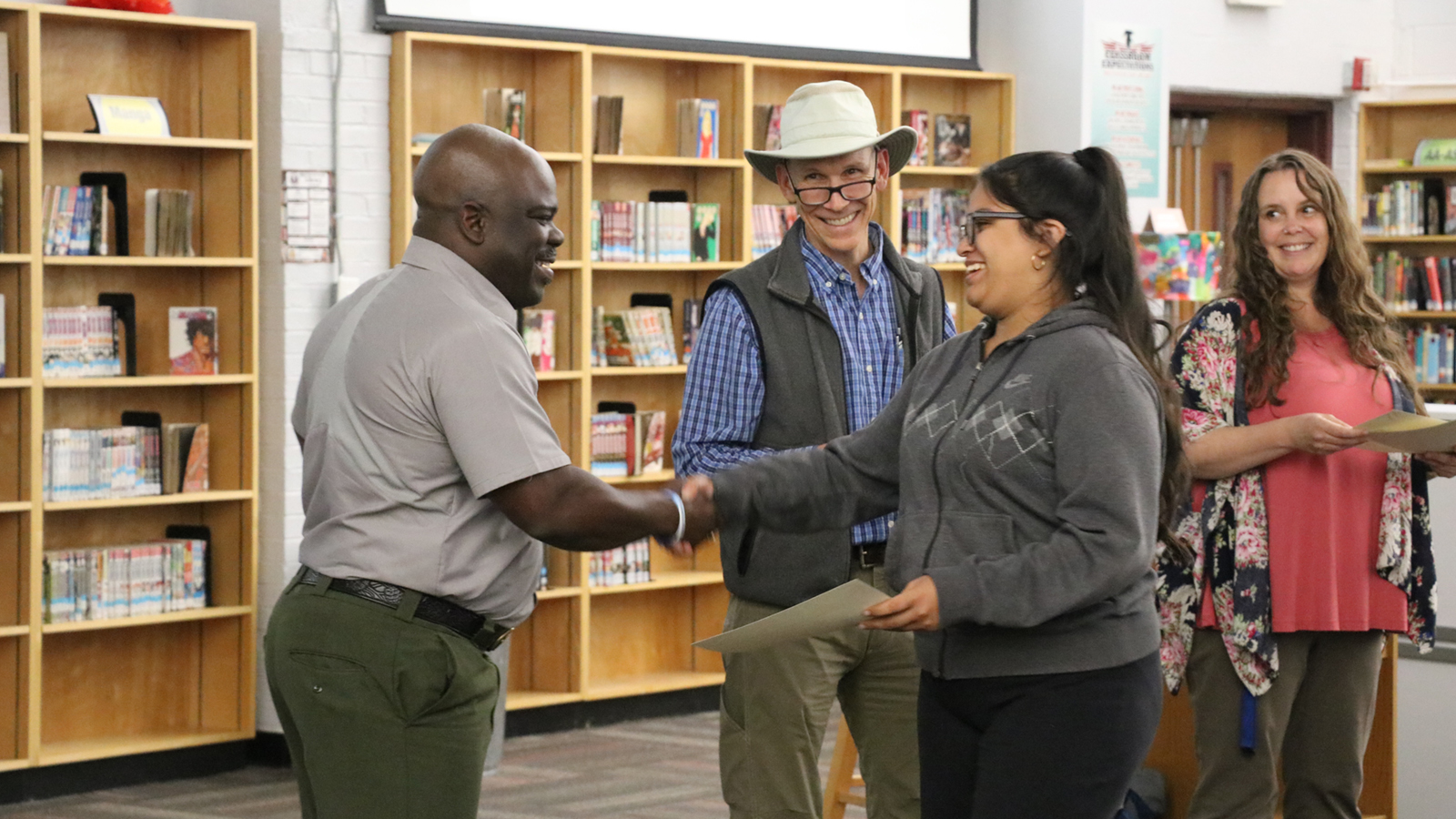 Gabriela Sanchez Benitez shakes hands with Great Smoky Mountains National Park Superintendent Cassius Cash. Also pictured: John DiDiego, Tremont Education Director, and Kimberly Kennard, Fulton High School Teacher.